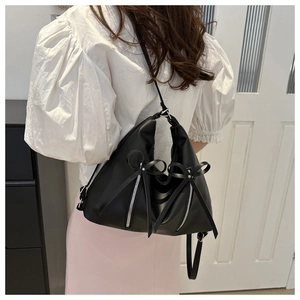 Détail du sac cabas triangulaire noir avec fermetures éclair argentées et nœud en cuir