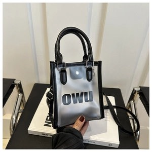Détail du sac en PVC givré transparent avec bordure en cuir noir et lettrage OWU