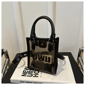 Détail du sac transparent en PVC noir avec lettrage OWU et poignées en similicuir noir