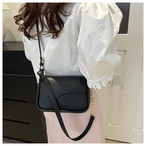 Détail du sac bandoulière noir avec sangle réglable et chaîne dorée décorative