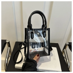 Détail du sac à main transparent en PVC avec bordure en cuir noir et logo OWU devant