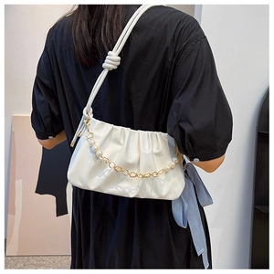 Detailed view of white pleated handbag with pearl chain and matte PU leather texture