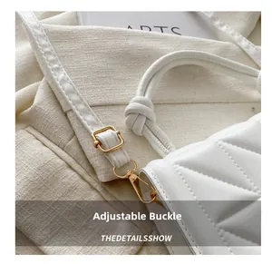 Detail of adjustable golden buckle and quilted texture on white leather bag