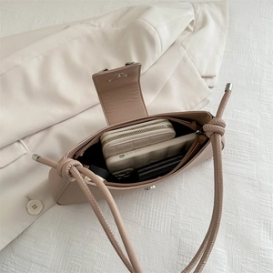 Minimalist beige baguette bag with leather texture showing interior storage capacity