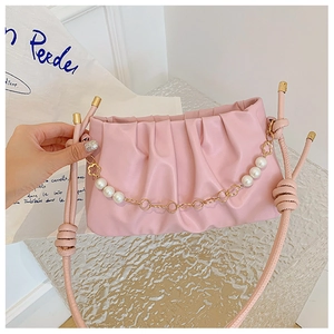 Detailed view of pink ruched cloud bag featuring pearl chain strap and gold hardware