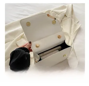 Detail showing internal capacity of the white leather crossbody bag with magnetic buckle