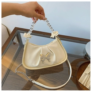 Detail of cream pleated cloud bag with silver butterfly buckle and beaded handle