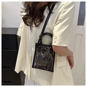 Vue détaillée du sac bandoulière transparent en PVC avec bordure noire porté par mannequin