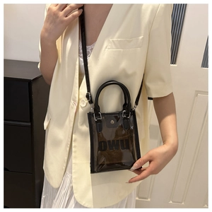Vue détaillée du sac transparent marron en PVC avec finitions en cuir noir et logo