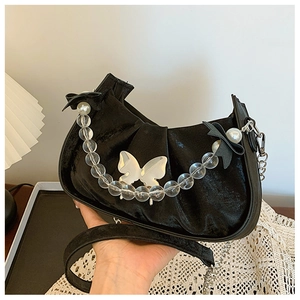 Detail of black velvet pleated half-moon bag with silver butterfly and beaded handle
