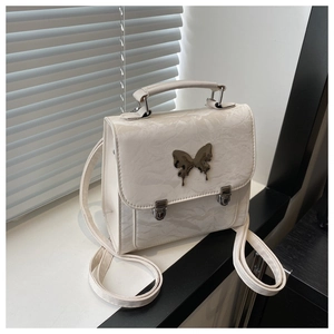 Close-up of white pleated texture backpack featuring a polished metal butterfly buckle