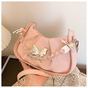 Detail of light pink pleated handbag with metal butterfly and acrylic bead chain strap