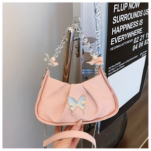 Detail of light pink shoulder bag with beaded chain handle and silver butterfly charm