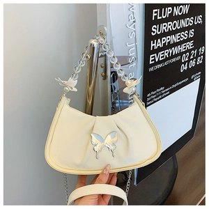 Detail of cream saddle bag with silver bow hardware and beaded handle with ribbon