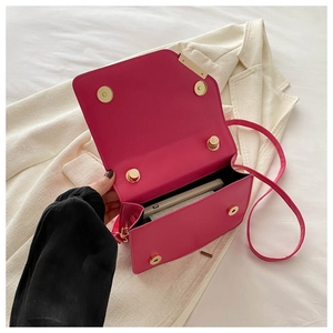 Detail view of hot pink crossbody square bag showing magnetic closure and interior space