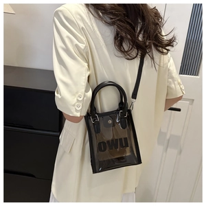 Détail du sac à main en PVC noir translucide avec logo OWU et bandoulière cuir