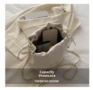 Internal view of the white bucket bag showing large capacity for phone and wallet