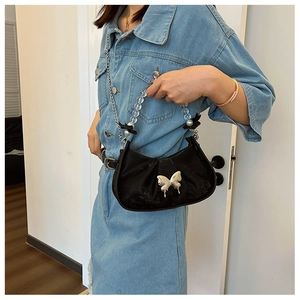 Detail of black crescent shoulder bag featuring silver butterfly clasp and beaded handle