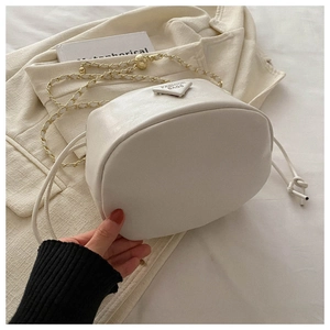 Close-up of white drawstring bucket bag with gold chain strap and triangle logo detail