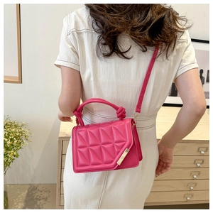 Rose red quilted PU leather shoulder bag with gold clasp and top handle on a model