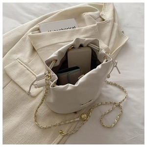 Interior view of off-white drawstring bucket bag showing phone and cardholder capacity