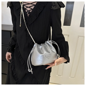 Detailed close-up of the silver bucket bag showing the metallic finish and chain strap