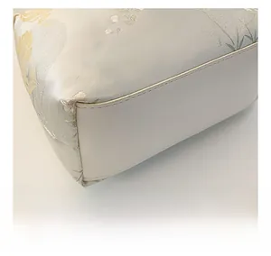 Close-up of stitching and floral jacquard fabric on stylish handbag bottom