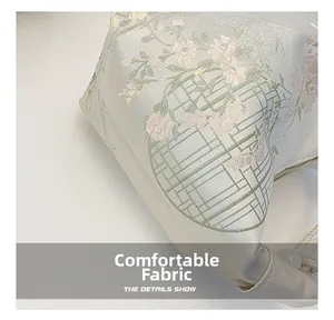 Macro shot of off-white satin fabric with delicate floral embroidery details on the bag