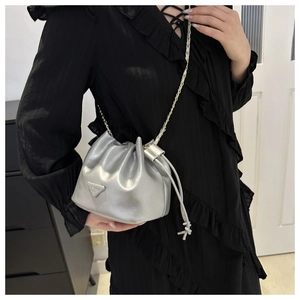Metallic silver drawstring bucket bag with chain strap and triangular logo plaque