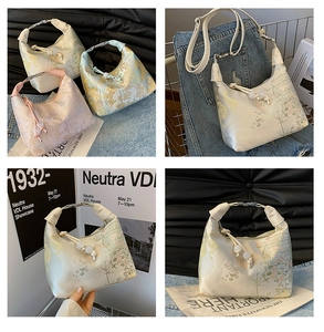 Detail of floral brocade handbag featuring metallic buckle and pearl bead drawstring