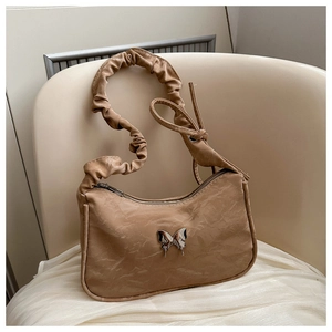 Detail of khaki crescent bag with ruffled strap and silver butterfly metal buckle