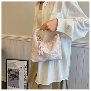 Detail of elegant jacquard small square bag with floral pattern and drawstring closure