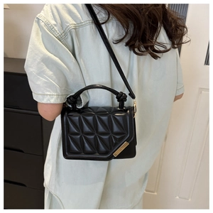 Quilted black leather crossbody bag with gold hardware shown on model back