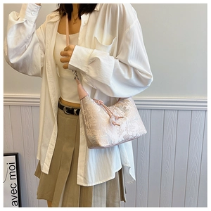 Close-up of light pink jacquard handbag featuring traditional Chinese floral patterns