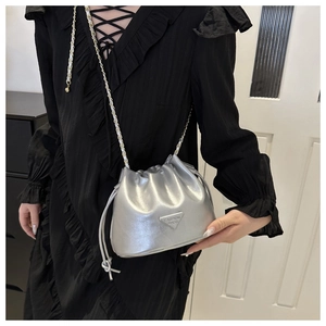Detail of silver drawstring bucket bag with chain strap and metallic logo plate