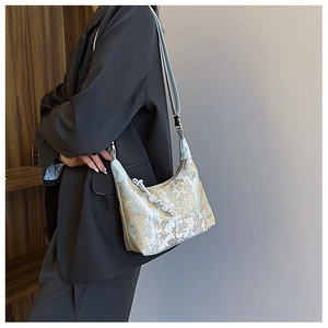 Close-up of Chinese style embroidered crossbody bag with floral patterns and leather straps