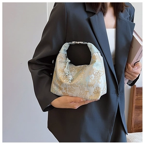 Close-up of brocade embroidery handbag with light blue fabric and silver metal handle