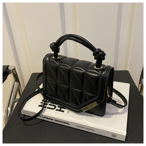 Detail of black quilted leather handbag with gold buckle and knot handle decoration