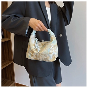 Detailed embroidery of tree and floral patterns on a light blue Chinese style handbag