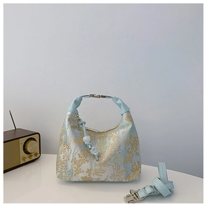 Detail of Chinese style handbag showing blue leather strap and floral embroidery texture