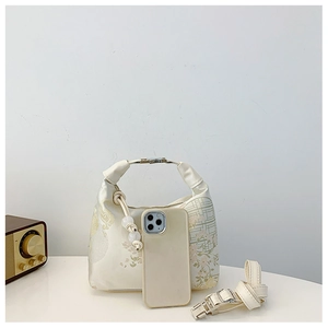Detail of silk brocade texture on Chinoiserie handbag with pearl charm and leather handle