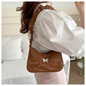 Brown pleated PU shoulder bag with silver butterfly charm and scrunchie strap detail