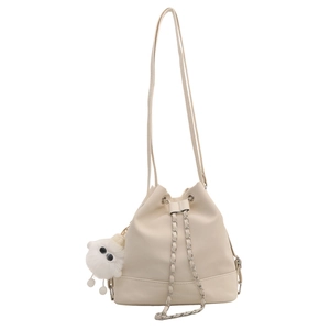 Chic cream white bucket backpack with chain drawstring and plush ball charm accessory