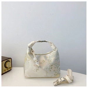 Detail of silk satin handbag featuring Chinese floral patterns and metallic buckle clasp