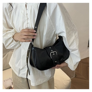 Détail du sac sous le bras en cuir noir avec boucle argentée et sangle à œillets