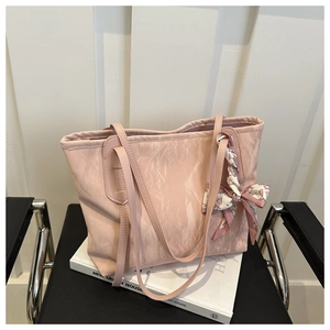 Nahaufnahme der rosa Marmor-Tragetasche mit Seidenschal auf einem Buch und Stuhl
