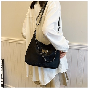 Detailed view of black matte hobo bag with silver butterfly charm and chain strap detail