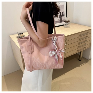 Detail of light pink tote bag featuring a decorative silk scarf and soft washed texture