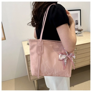 Rosa Nylon-Tragetasche mit modischem Schal und schmalen Schultergurten an einem Model