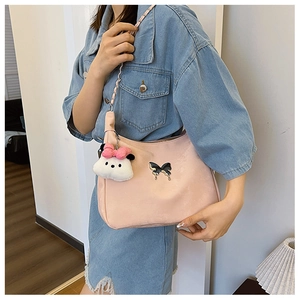 Pink minimalist crossbody bag with metal butterfly detail and plush rabbit keychain